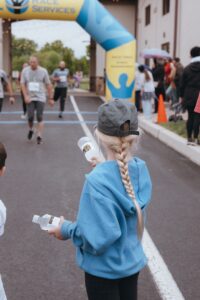 youth handing water bottles to 5k runners at 2026 move for life